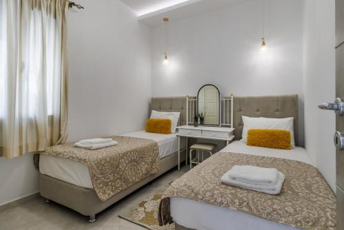 a bedroom with two beds and a sink and a mirror at Villa Ameli in Neo Klima