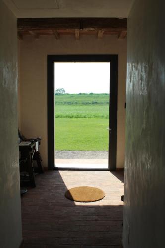 a door to a room with a large window at Corte LOIOL in Scorzarolo