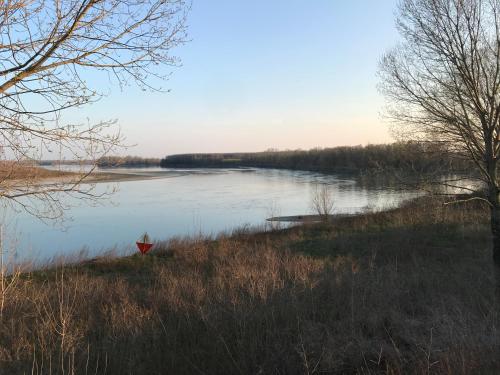 a view of a lake with a red boat in the water at Corte LOIOL in Scorzarolo
