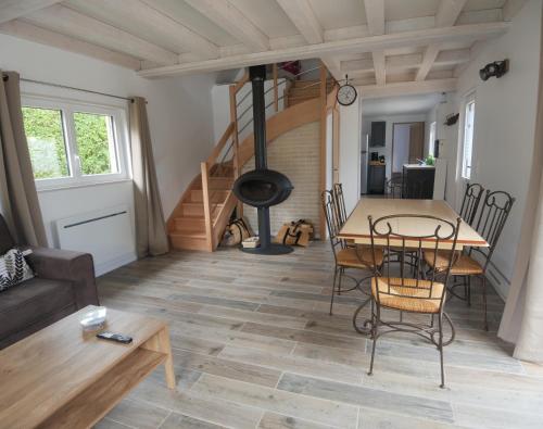 un salon avec une table et une cheminée dans l'établissement La Grange, à Auberville