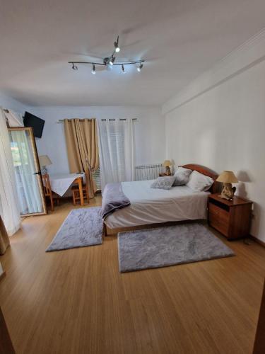 a bedroom with a bed with two rugs on the floor at Recanto da Serra - Alojamento Local in Lousã