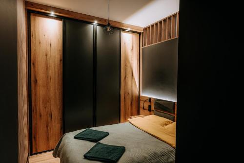 a bedroom with a bed and a black wall at Apartament Mazury Kętrzyn „Kopernik” in Kętrzyn