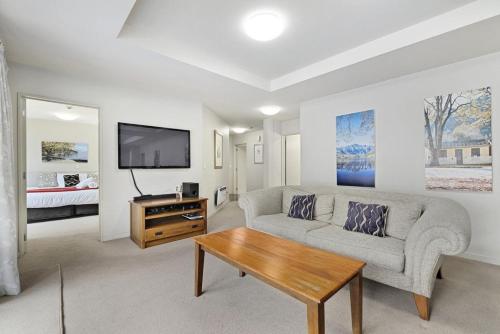 a living room with a couch and a table at The Glebe Apartments in Queenstown