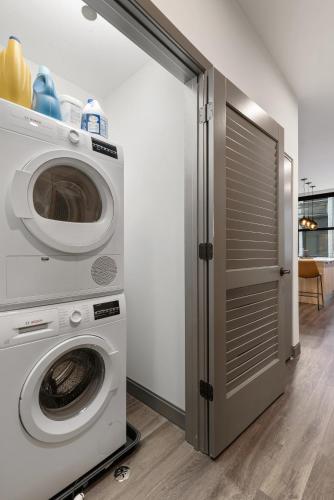 a washer and dryer in a room with a door at Experience Downtown Chicago at Millennium - Luxury Apartments in The Loop in Chicago