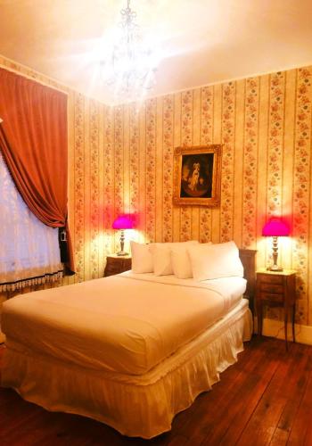 a bedroom with a large bed with two lamps at Copper Queen Hotel in Bisbee