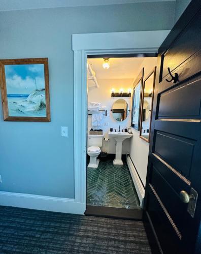 a bathroom with a sink and a toilet and a door at Gifford House in Provincetown