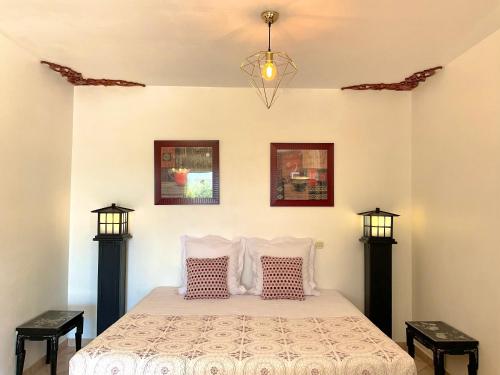 1 dormitorio con 1 cama con 2 mesitas de noche en Chambres d'hôtes Les Noisetiers, en Digne-les-Bains