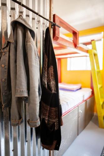 a row of hats hanging on a rack in a bedroom at Cloudcroft Hostel in Cloudcroft