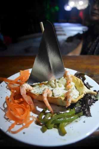 a plate of food with two knives on top at Pousada La Luna in Paracuru