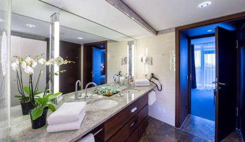 a bathroom with two sinks and a large mirror at Dorint An der Kongresshalle Augsburg in Augsburg