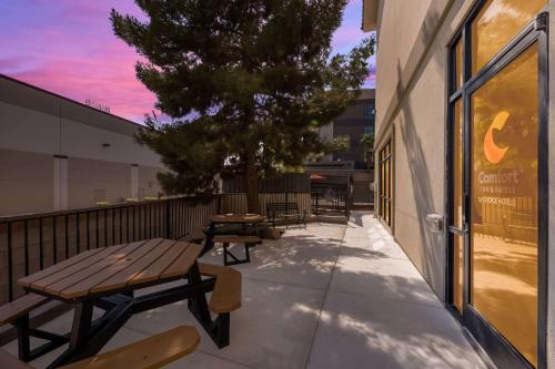 a patio with benches and a tree on the side of a building at Comfort Inn & Suites Las Vegas - Nellis in Las Vegas