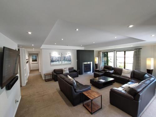 a living room with couches and a flat screen tv at The Glebe Apartments in Queenstown