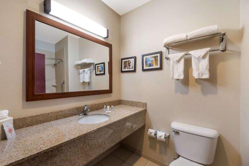 uma casa de banho com um lavatório, um espelho e um WC. em Comfort Inn & Suites Las Vegas - Nellis em Las Vegas