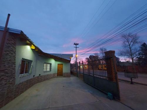 a building with a gate in front of a street at Malargüe al Sur, departamentos in Malargüe