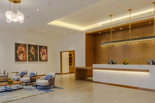 a lobby with a waiting room with chairs and a counter at Clarion Hotel Jeddah Airport in Jeddah