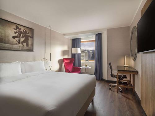 um quarto de hotel com uma cama grande e uma secretária em Radisson Blu Royal Viking Hotel, Stockholm em Estocolmo