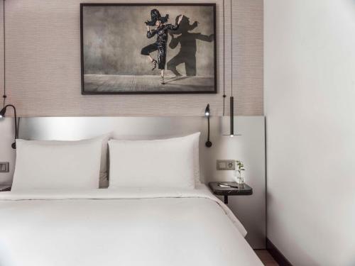 a bedroom with a white bed and a painting at Radisson Blu Royal Viking Hotel, Stockholm in Stockholm