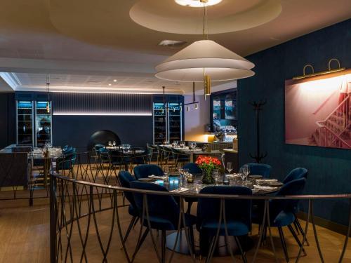 a dining room with tables and chairs and a large chandelier at Radisson Blu Royal Viking Hotel, Stockholm in Stockholm