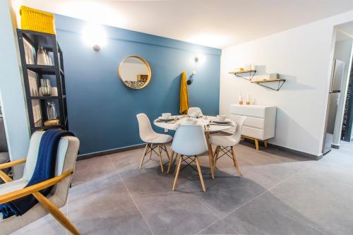 a dining room with blue walls and a table and chairs at NIU Modern & Centric Lofts in Mexico City