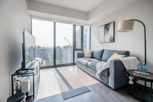 a living room with a couch and a large window at Traveller home in centre Toronto in Toronto