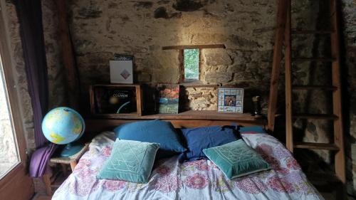 a bedroom with a bed with pillows and a ladder at Chambre insolite in Saint-Mathieu