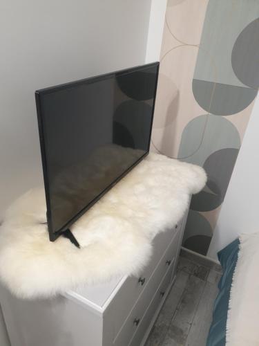 un téléviseur à écran plat posé sur une commode dans l'établissement La green, à Brétigny-sur-Orge