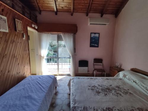 科隆Depto Luis的一间卧室，配有两张床和一个大窗户