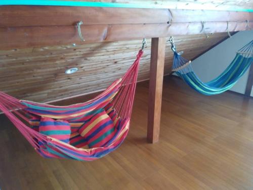 a hammock hanging from a wooden table at 八丈島メープルハウス in Hachijo