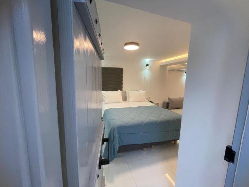 ein kleines Schlafzimmer mit einem Bett und ein Zimmer mit in der Unterkunft Coco Luxury Apartments in Poros