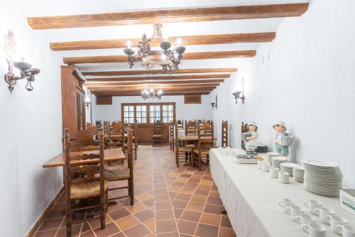 uma sala de jantar com mesas e cadeiras brancas em Hotel Rincón Castellano em Cuéllar