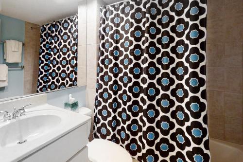 a bathroom with a black and white shower curtain at Captains Court 1031 in Fernandina Beach