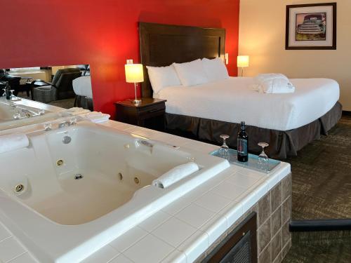 a hotel room with a large bath tub and a bed at Coast Swift Current Hotel in Swift Current