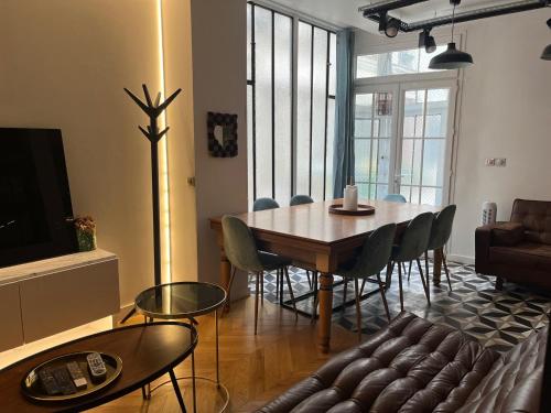 un salon avec une table, des chaises et un canapé dans l'établissement Design appartment in the marais, à Paris
