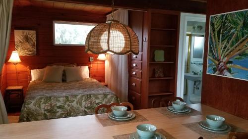 ein Schlafzimmer mit einem Bett und einem Tisch mit Tassen in der Unterkunft Palm View: Secluded Oasis in Melbourne Village in Melbourne Village