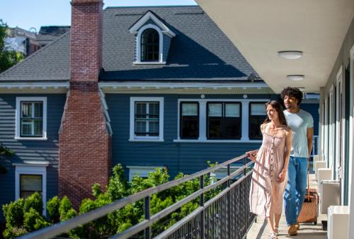 a man and a woman walking in front of a house at Park Lane Suites & Inn in Portland