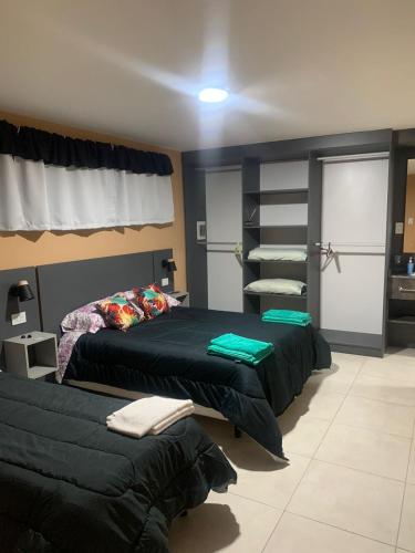 1 dormitorio con 2 camas y sofá en Departamento Kuyen en Malargüe