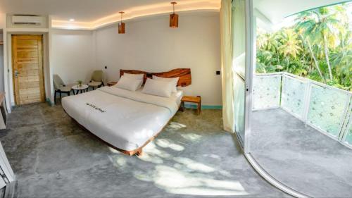 a bedroom with a bed and a large window at Silver County Hotel, Fuvahmulah - Maldives in Fuvahmulah