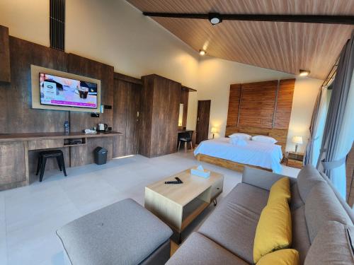 a living room with a couch and a bed at Taman Dari Villa in Sudaji