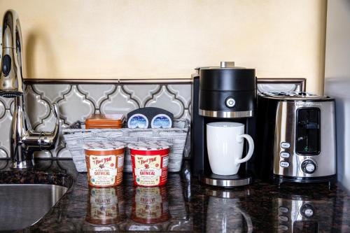 a counter top with three cups and a coffee maker at Park Lane Suites & Inn in Portland