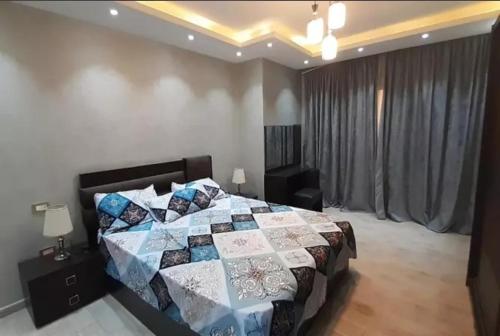 een slaapkamer met een bed met een quilt bij HousRom in Caïro