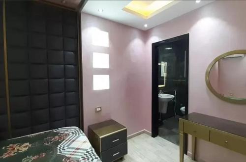een slaapkamer met een bed en een badkamer met een spiegel bij HousRom in Caïro