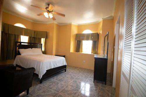 a bedroom with a bed and a ceiling fan at Round View Guest House in Port Antonio