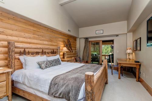 The Lodges at Deer Valley 3 Units في بارك سيتي: غرفة نوم بسرير وجدار خشبي