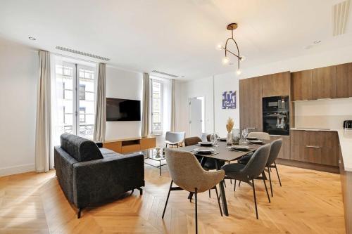 un salon avec une table et des chaises et une cuisine dans l'établissement Stunning apartment - 2BR-6P - Opéra, à Paris