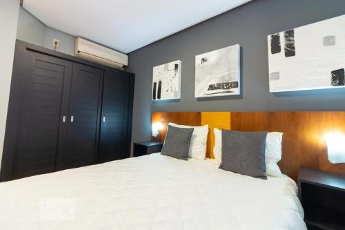 a bedroom with a large white bed with two pillows at Flat em Moema (SP) in Sao Paulo