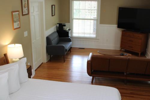 a bedroom with a bed and a couch and a television at The Emory House in Emory