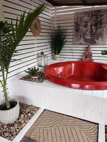 a red tub in a bathroom with a statue at PAZ Y ARMONÍA en chuy 2 in Chuy