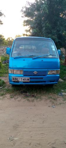 uma carrinha azul estacionada na relva ao lado das árvores em Mramba safaries car hire and tax service em Kilifi