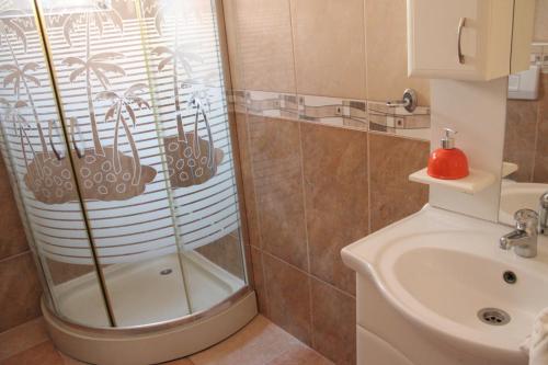 een badkamer met een douche, een toilet en een wastafel bij Egnatia Apartments in Struga