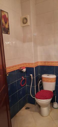 a bathroom with a toilet with a red lid at مجمع الزموري 3 in Tangier